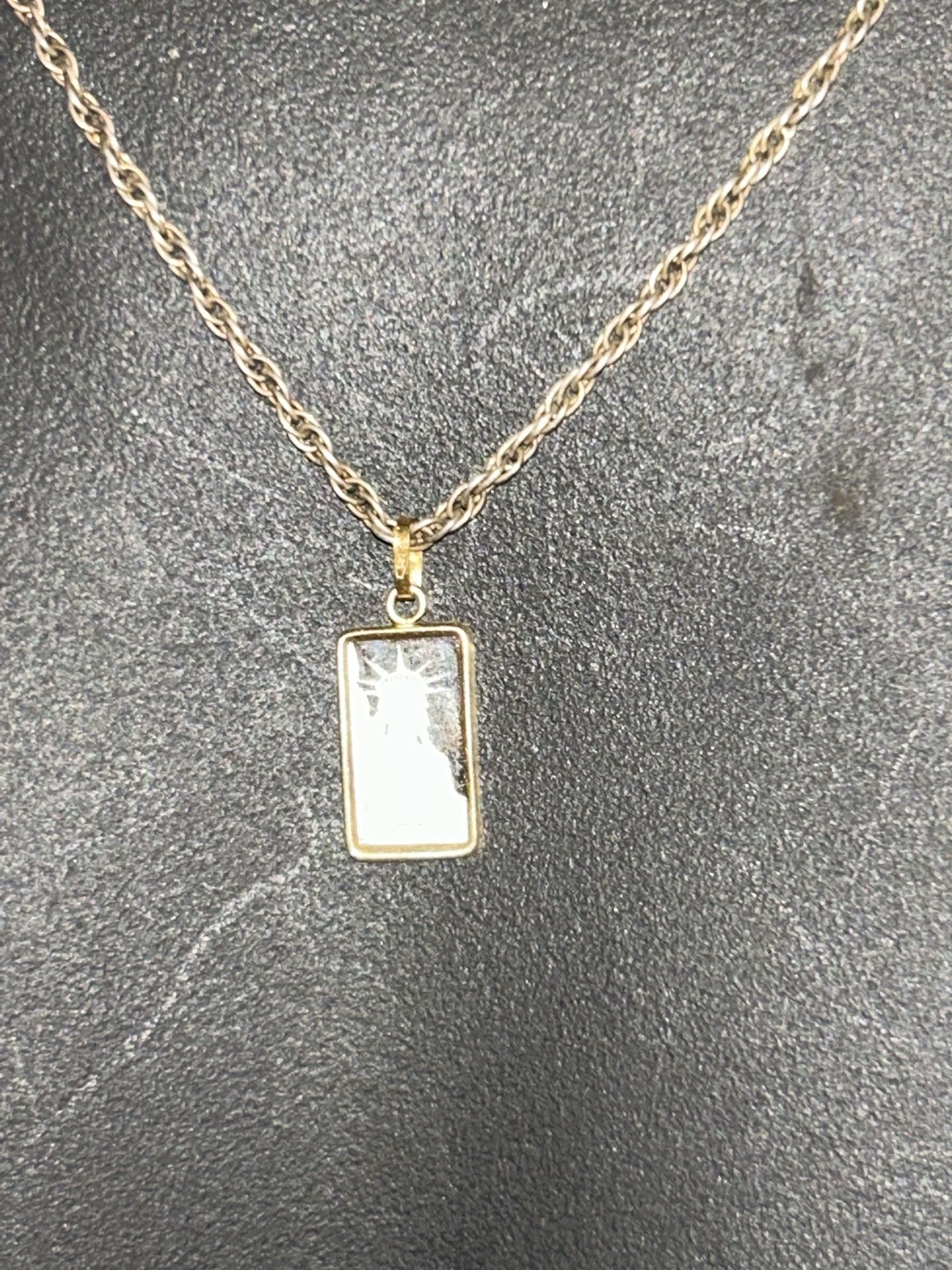 18 in.² silver solid rope chain with a 14 karat holding a 1 g platinum bar