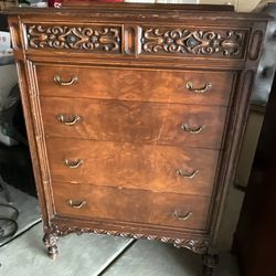 Antique Carved Dresser With Brass Hardware On Wooden Wheels