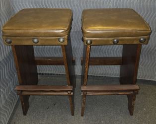 Vintage wood bar stools with a rectangular cushioned seat and brass stud detailing