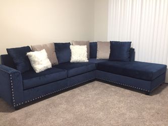 Brand new velvet upholstered sectional with nail head trim.