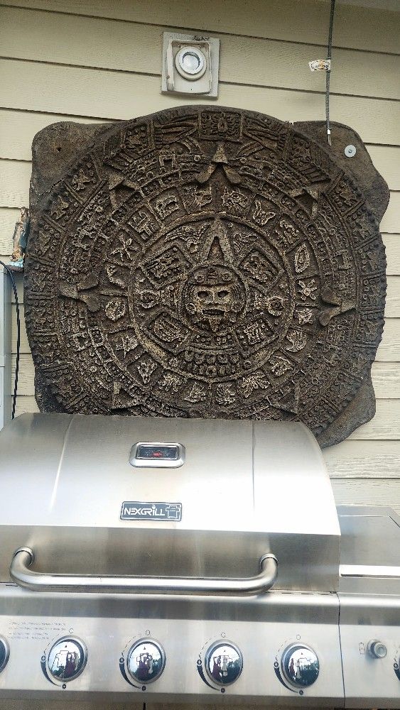 Aztec calendar made of newspaper, 3x3 feet, with a view of rock, 2 inches thick, with plywood on the back for strength.