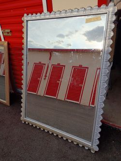 Large silver tone mirror. Measurements is written on the mirror in the picture