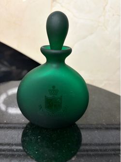 Green frosted glass bottle gesty the crest of The Peninsula Hotel
