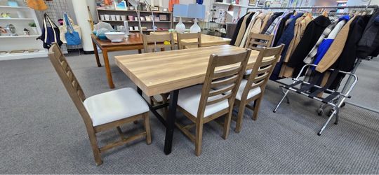 A rustic wood-finish rectangular trestle table with a black metal X-base