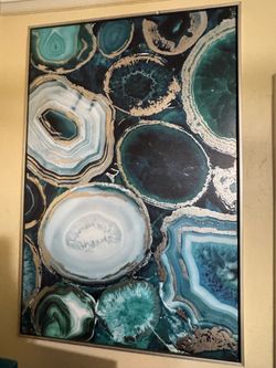 wall art is a teal / green and gold abstract geode or agate slice-patterned framed canvas print.