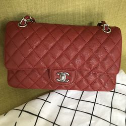 CHANEL. Red quilted lambskin handbag with a handle and a…