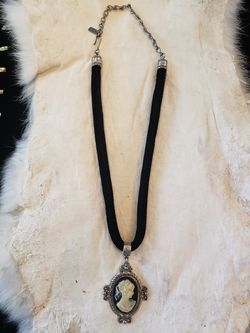 $10. Beautiful cameo inspired necklace pendant. Necklace is made of metal and felt type fabric.