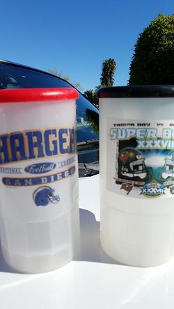 Two plastic mugs with lids one Chargers mug and won Super Bowl mug Tampa Bay and Oakland from Super Bowl 37 both license products