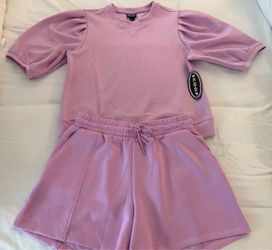 This pink Scoop scubaknit matching set features a short-sleeve top with dramatic pleated puff sleeves paired with coordinated drawstring lounge shorts
