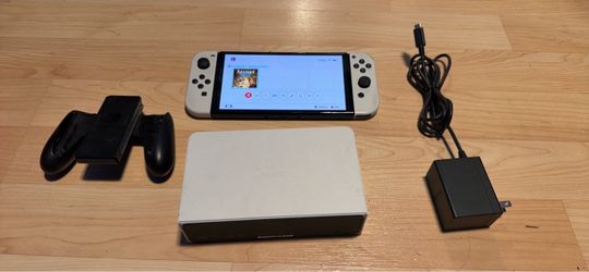 Nintendo switch OLED with docking station, joycon grip, rayman game and charger. No trades cash only see my other listings for more gaming stuff.