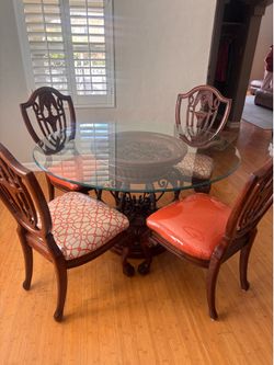 Beautiful glass table with 4 custom chairs that are covered