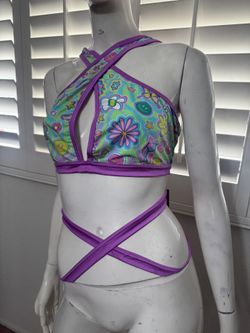 New floral-print crop top with a front keyhole cutout. Crisscross halter straps and wrap-around ties. Bright, colorful pattern for festivals or beachw