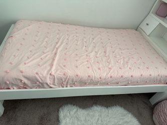 White wooden single bed with headboard storage