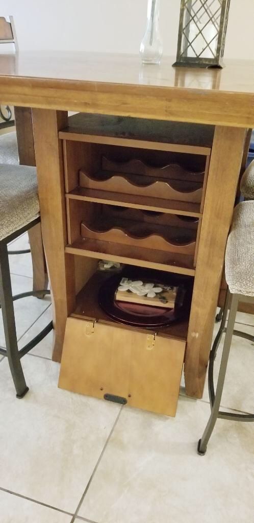 Brown dining table with built in wine rack and chairs