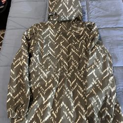green and cream zig-zag patterned hooded rain jacket by The North Face.  Women’s Size Large. Like New