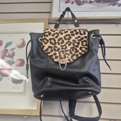 Dune London black leather and leopard print calf hair backpack featuring a gold-tone turn lock and chain detail.