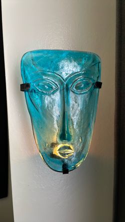 Glass mask w candle behind