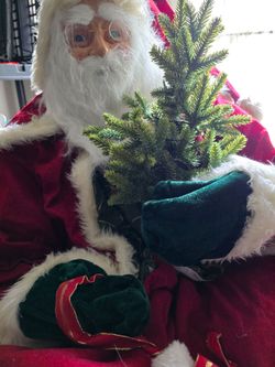Inflatable realistic santa seating in a chair