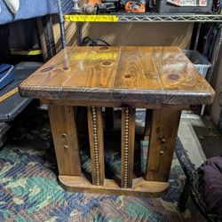 rustic wood end table with decorative studding on the leg