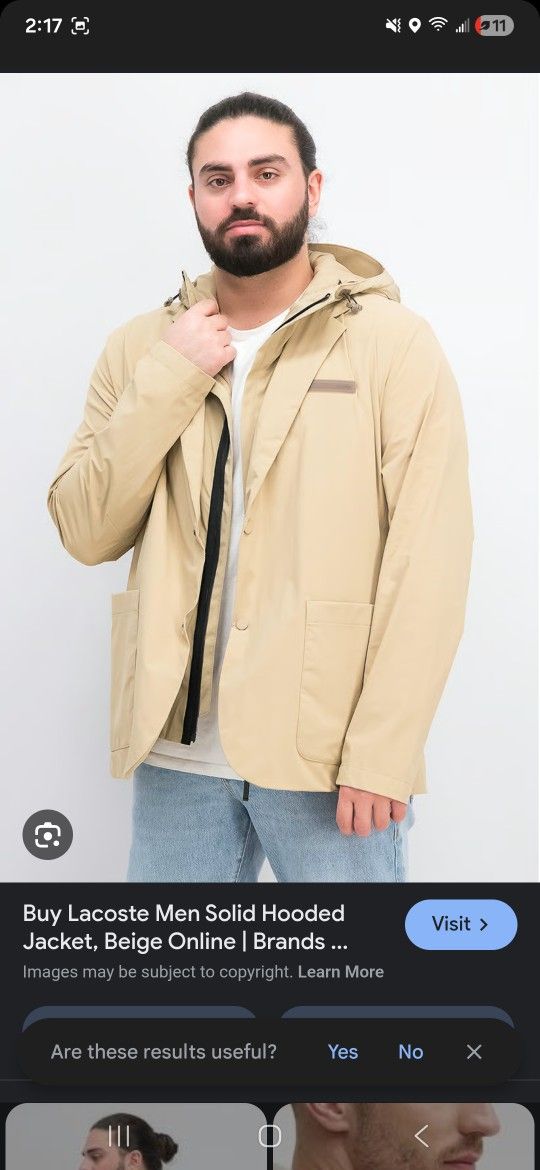 Lacoste beige rain jacket. Slit on the back. Front closure with press studs. Two patch pockets on the front. Sleeveless hooded jacket inside can be wo