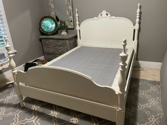 White wooden full size bed frame and boxspring mattress.