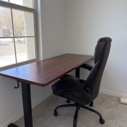 Wood sit/stand desk with leather office chair.
