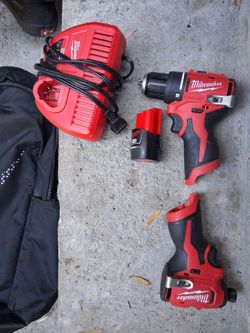 Two Milwaukee drills with battery and  charger and bag