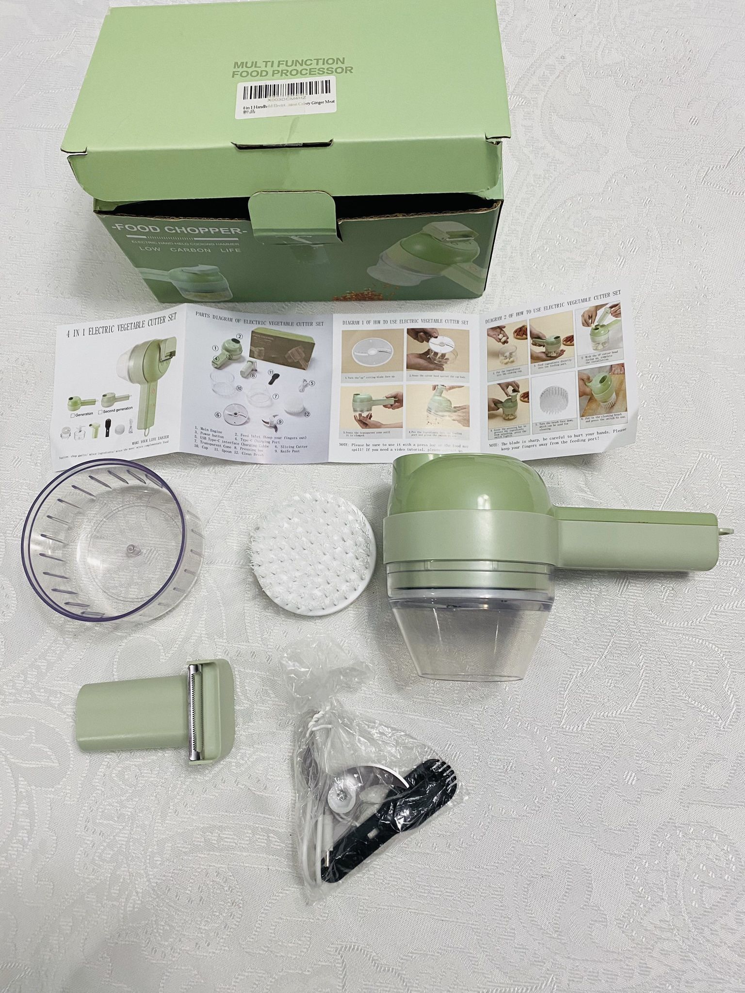 Electric 4-in-one Hand-Held Food processor. Includes functions such as slicing, mincing, peeling, and cleaning brush. New. Still in original packaging