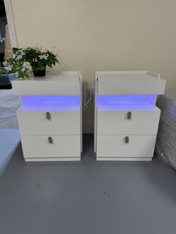 Brand new Sleek white nightstands, a pair. Has cool LED lights and convenient charging ports. Each nightstand has two drawers for storage. 