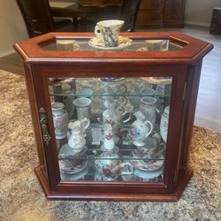 Wooden cabinet with Antique cups and saucers with other things