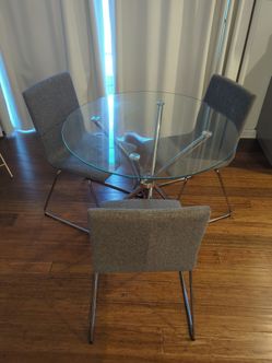 Glass dining table with three chairs