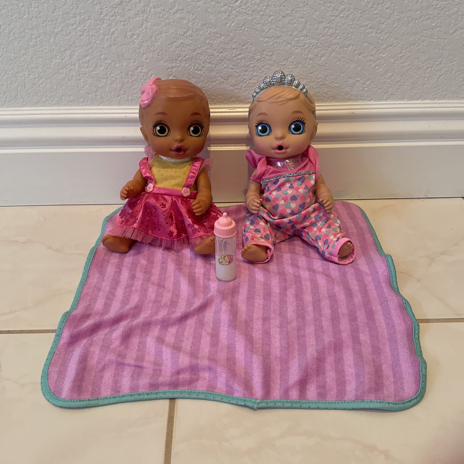Two Toy Babies With A Bottle And A Blanket
