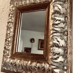 Beautiful elegant framed mirror H13.5xW21.5xD2 inch Lbs 4.3 Decorative wall accent, quality heavy solid frame. Silvery gold color; Excellent condition
