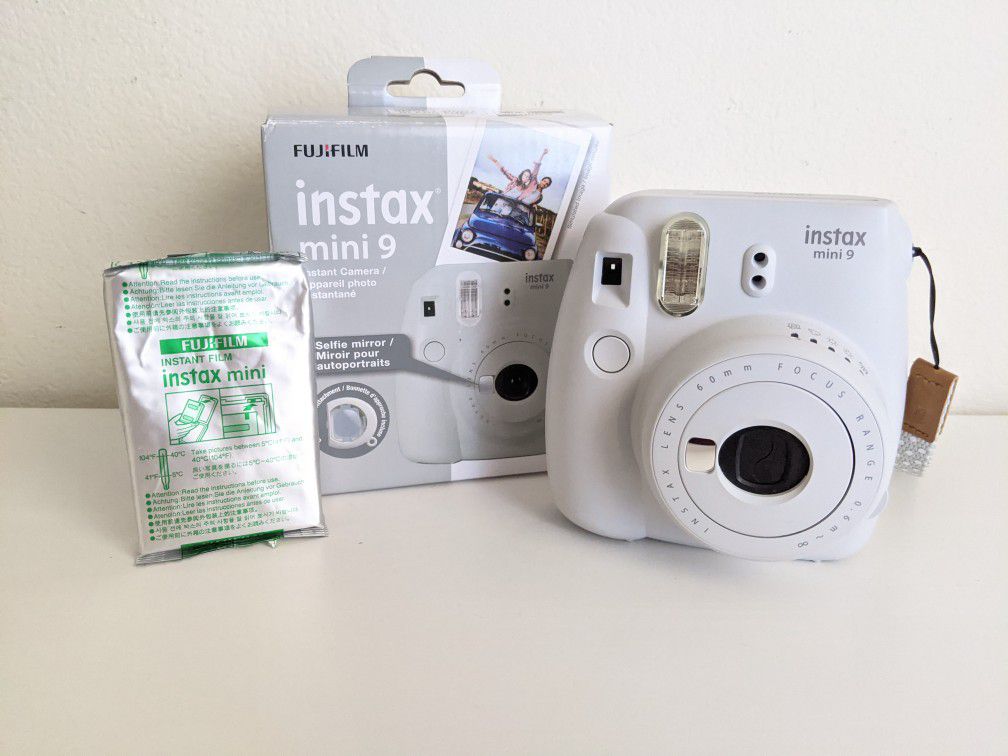 White Instax Mini 9 camera with film
