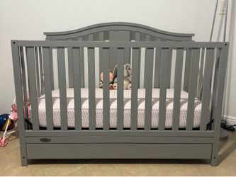 Gray Graco crib with bottom drawer