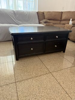 Dark brown coffee table with lift up top and drawers.