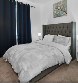 Full-size upholstered bed frame with tufted headboard and mattress.