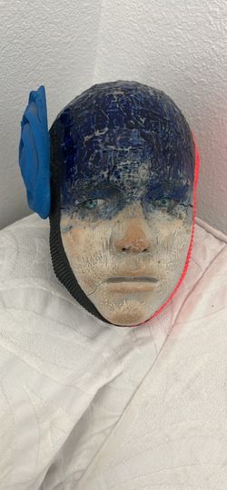 Unique handcrafted face mask / head sculpture featuring striking color contrast, deep blue glazed top detailing, textured facial features, and a blue