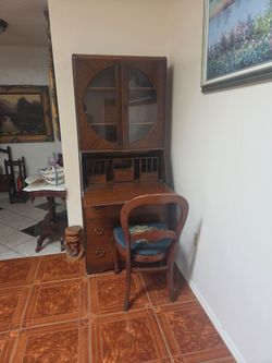 vintage wooden drop-front secretary desk with a glass-door bookcase hutch top and lower storage drawers with chair