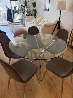Round glass dining table whit 5 grey chairs