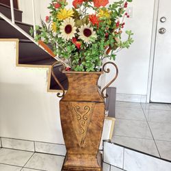 metal vase containing flowers.