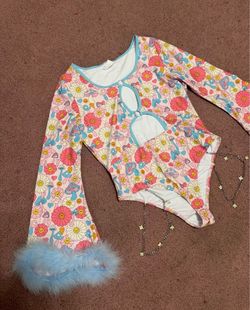 Playful floral bodysuit with strategic cutouts. Long sleeves finished with blue feather cuffs. Light blue trim accents neckline and cutouts. Soft stre