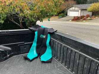 Stearns shorty wetsuit in black and teal neoprene with short sleeves and short legs. Bold teal panel design with Stearns branding on the chest and leg