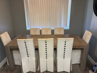 Universal Furniture Langston dining table in the Flint finish with 6 tall upholstered dining chairs.