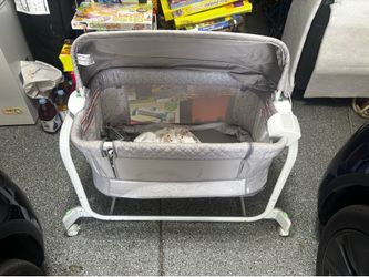 Versatile gray bassinet has a gliding motion in