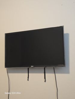 LG Flat Screen With The Control And Hooks With The Wall