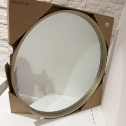Large round mirror with a gold frame.