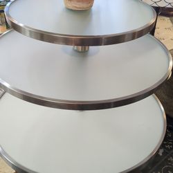three-tiered round display table, widest part  measures 3 ft in diameter 51 and 1/2 in tall