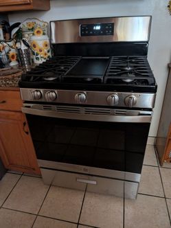 New GE Gas Stove Stainless Steel with Griddle in the middle.