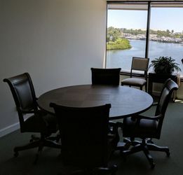 Four leather swivel office chairs.